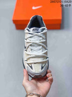 Top-down view of the sneaker showing white laces, a padded tongue, grey and white upper panels, and contrast detailing near the toe.