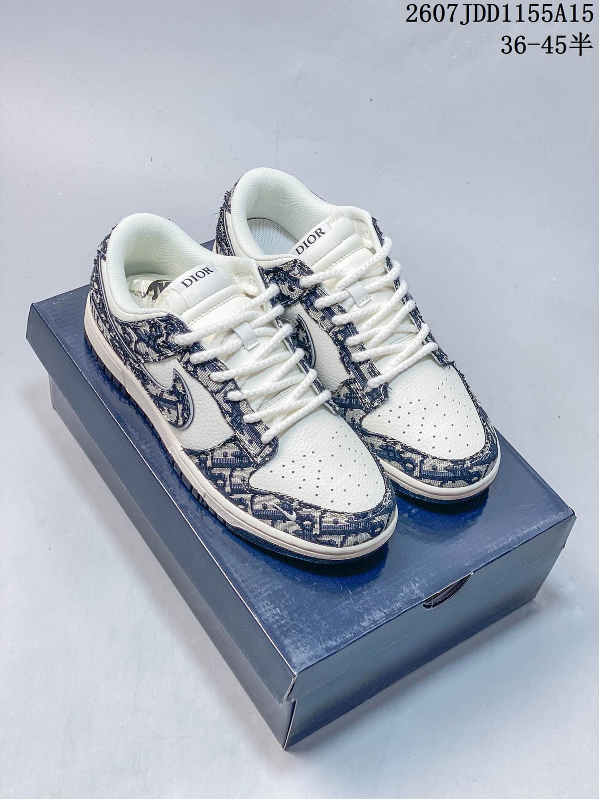 Pair of white and navy low-top sneakers with patterned panels, Nike branding, and a Dior-branded box; overlay shows code 2607JDD1155A15 and size range 36–45.5.