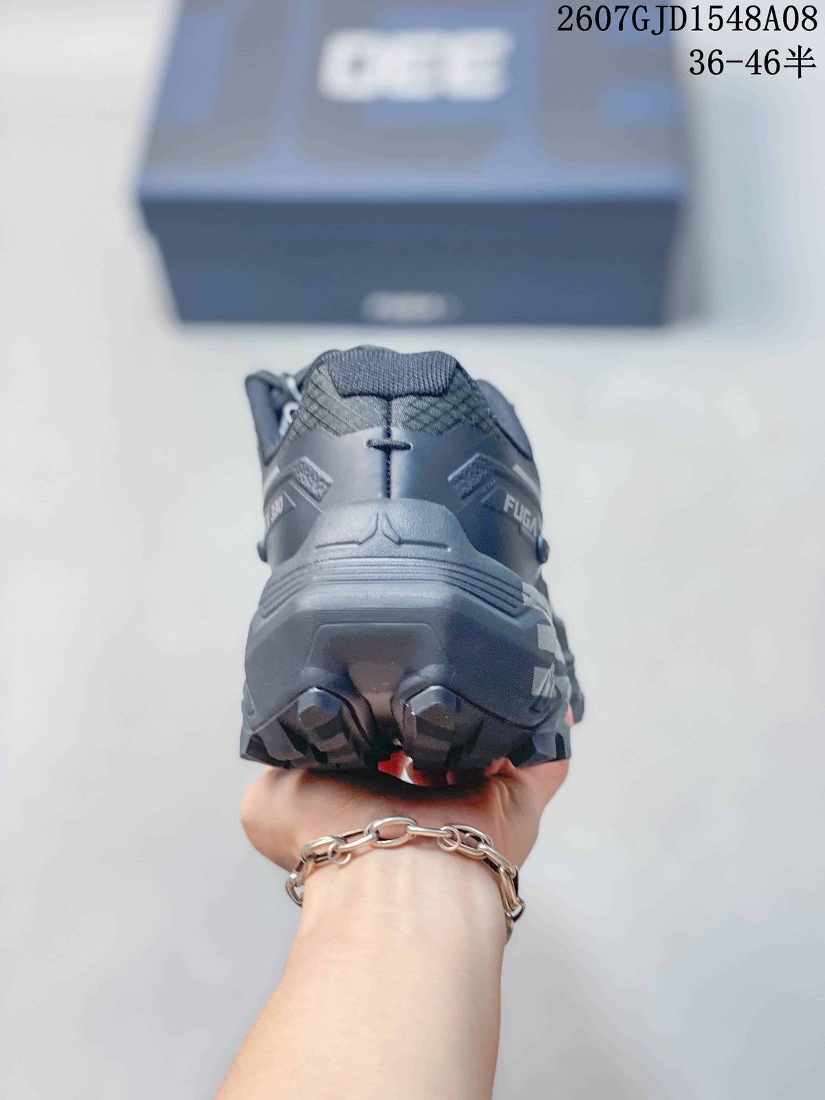 Rear view of the dark gray trail shoe showing the padded heel structure and lugged outsole.