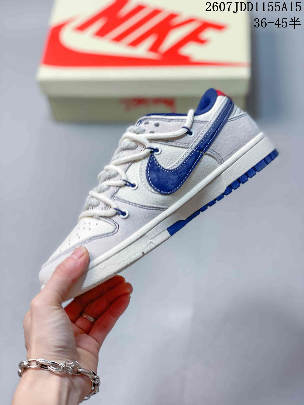 Side profile showing the navy Swoosh, grey heel panel, white midsole and navy outsole.
