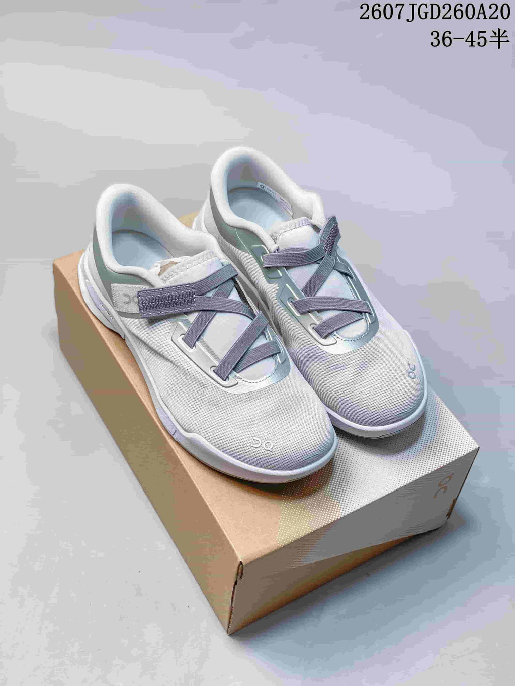 Pair of white On Cloudnova Moon sneakers with pale green and blue accents displayed on a shoebox.