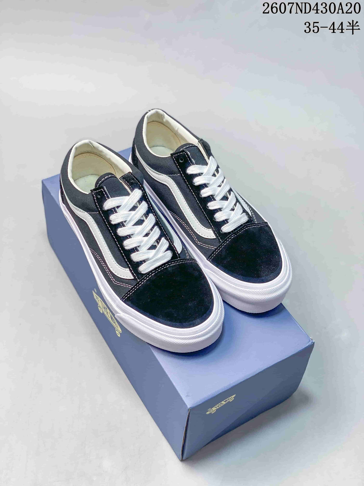 Pair of black and white Vans Old Skool 36 sneakers displayed on a shoe box.