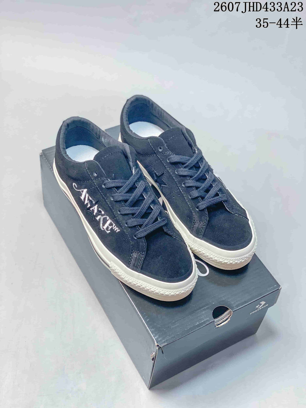 Pair of dark navy Converse low-top sneakers displayed on a Converse shoebox.