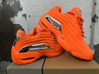 Pair of bright orange sneakers shown from the side, highlighting their sculpted design and silver-tone accents.