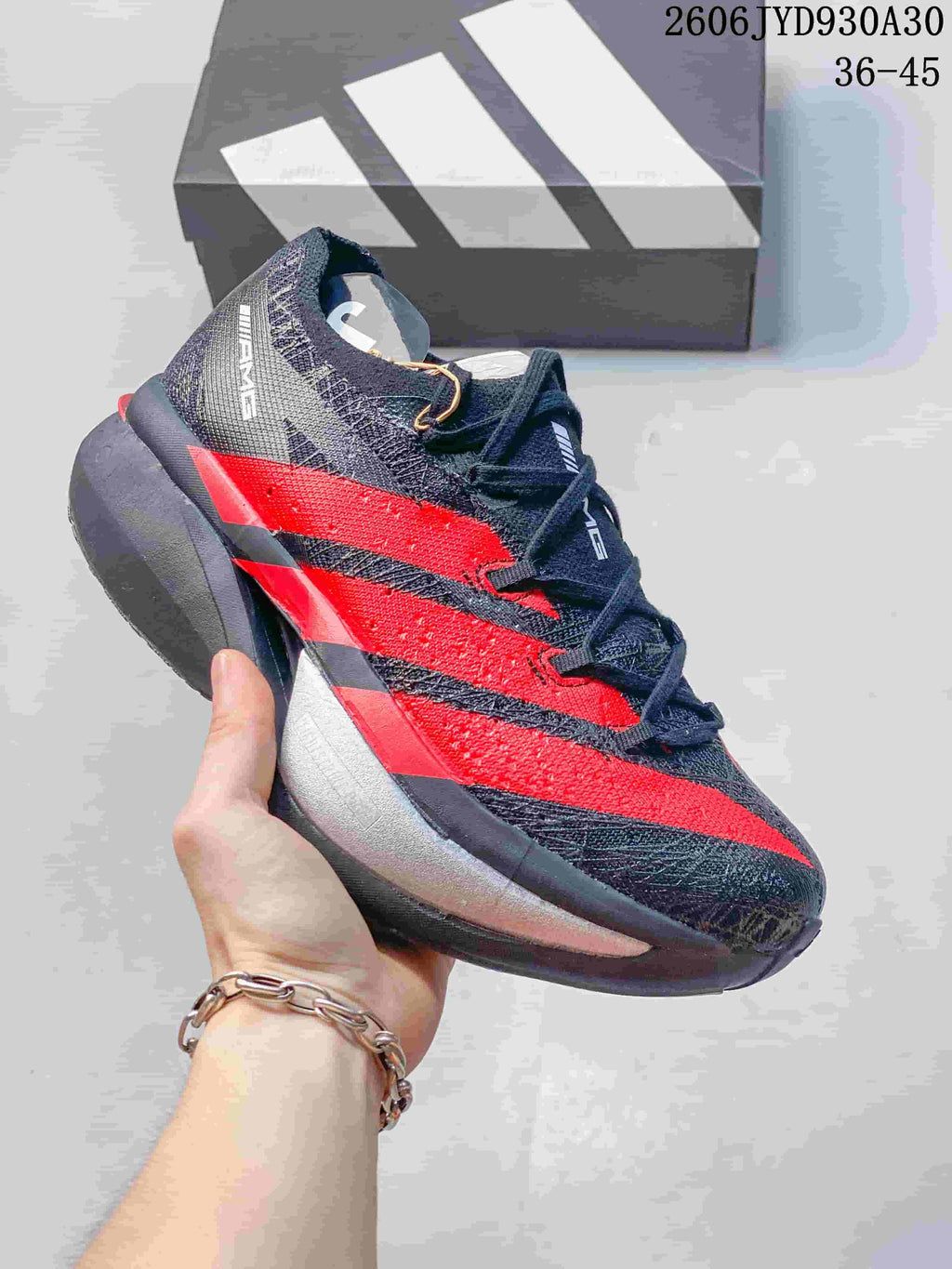 Black and red adidas Adizero Prime X3 shoe with a gray heel and sole.