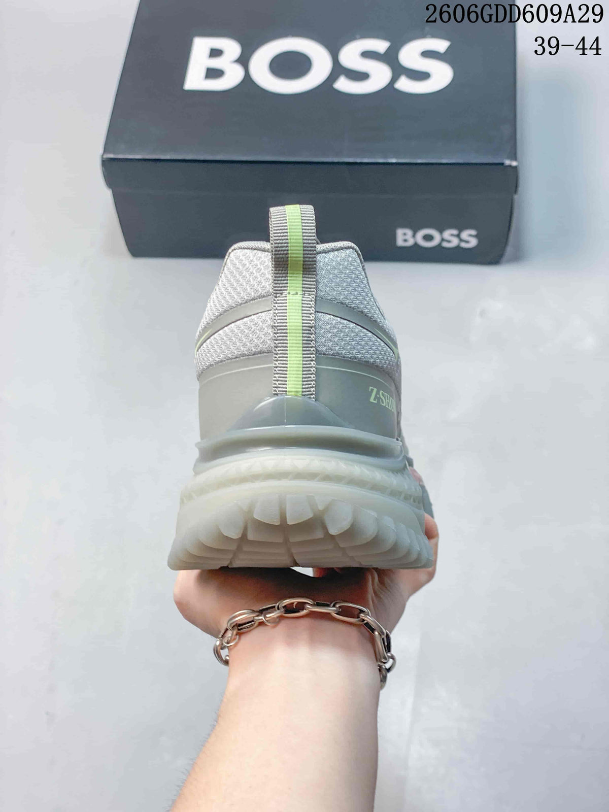 Rear view of a grey BOSS sneaker showing the heel pull tab