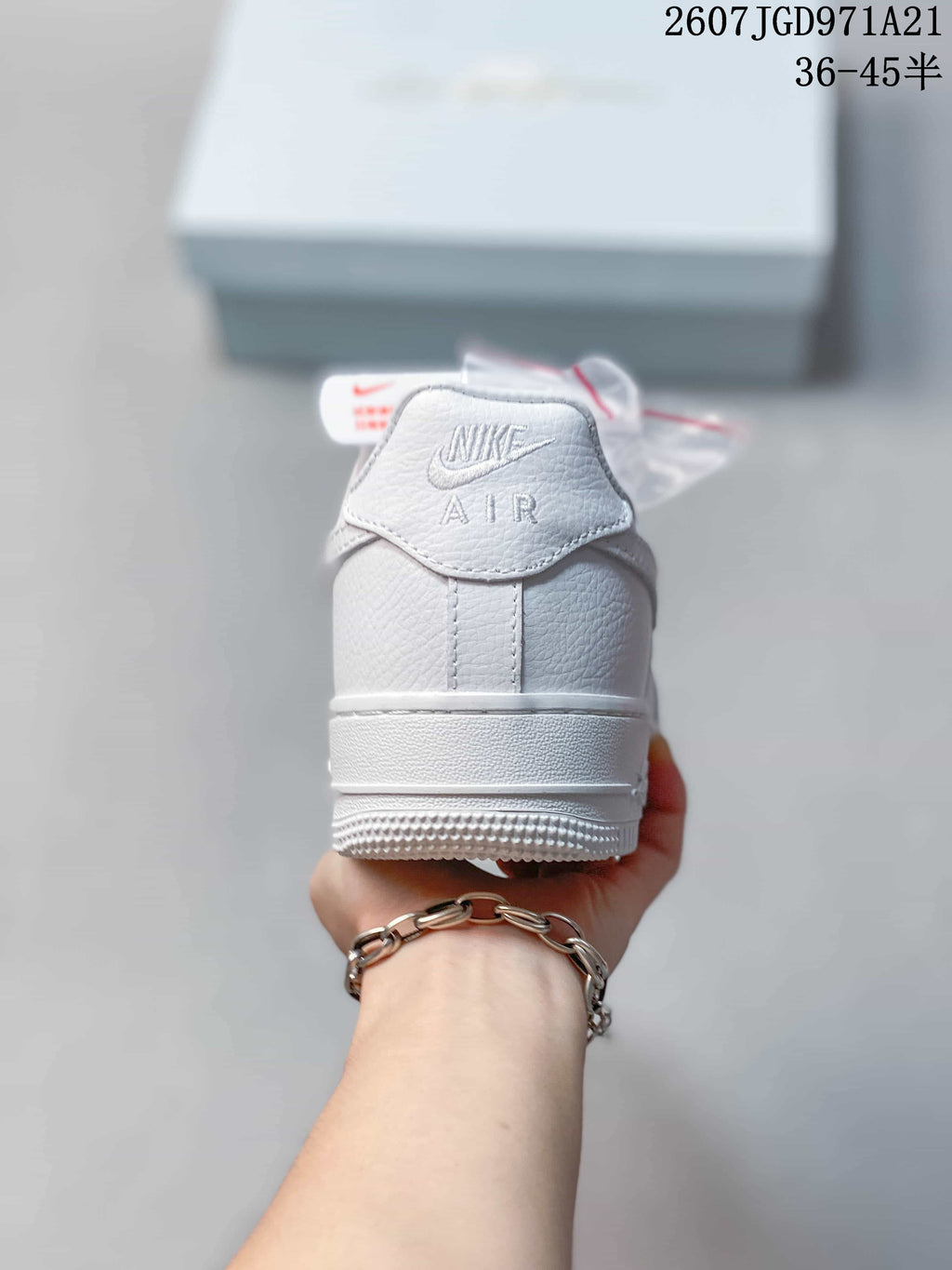 Rear view of the white sneaker showing the embroidered Nike AIR heel detail and rubber heel section.