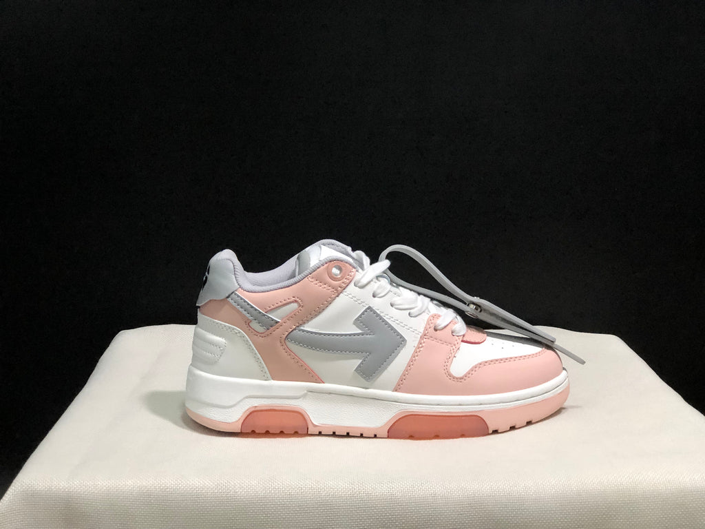 Side profile of one white, pink and grey low-top sneaker against a dark background.