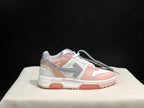 Side profile of one white, pink and grey low-top sneaker against a dark background.