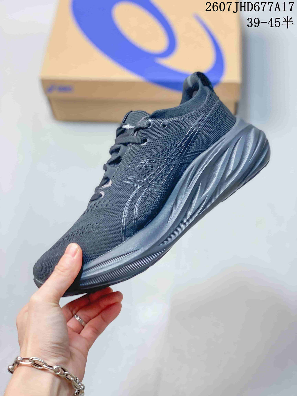 Side profile of a black ASICS running shoe showing the textile upper, side branding and sculpted midsole.