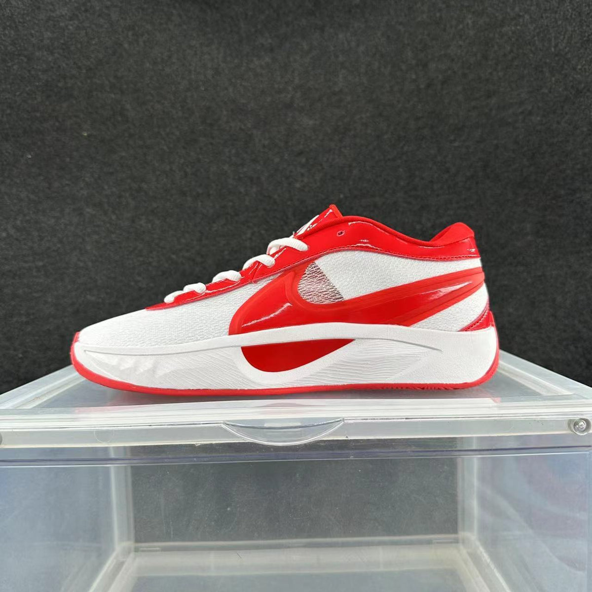 Side view of a red and white low-top Nike sneaker with white laces and a sculpted midsole.