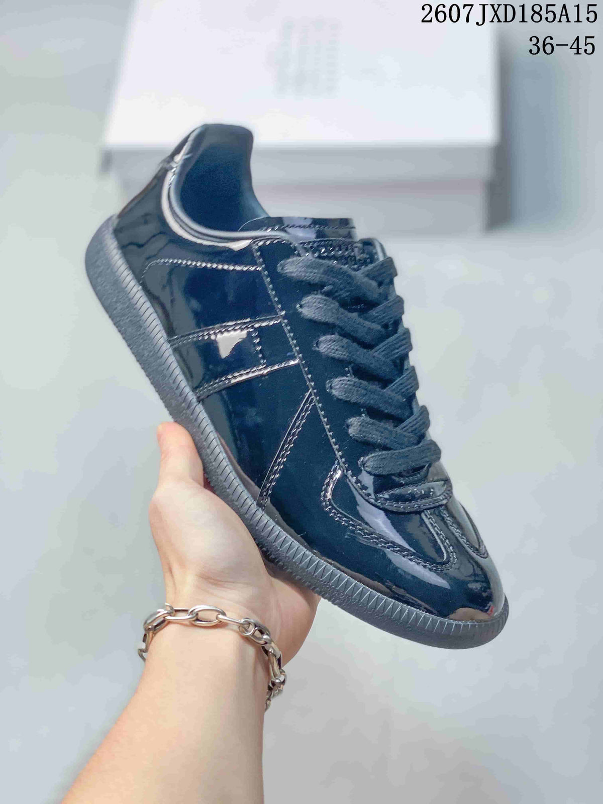 Angled side view showing the glossy dark upper, layered panels and textured outsole.