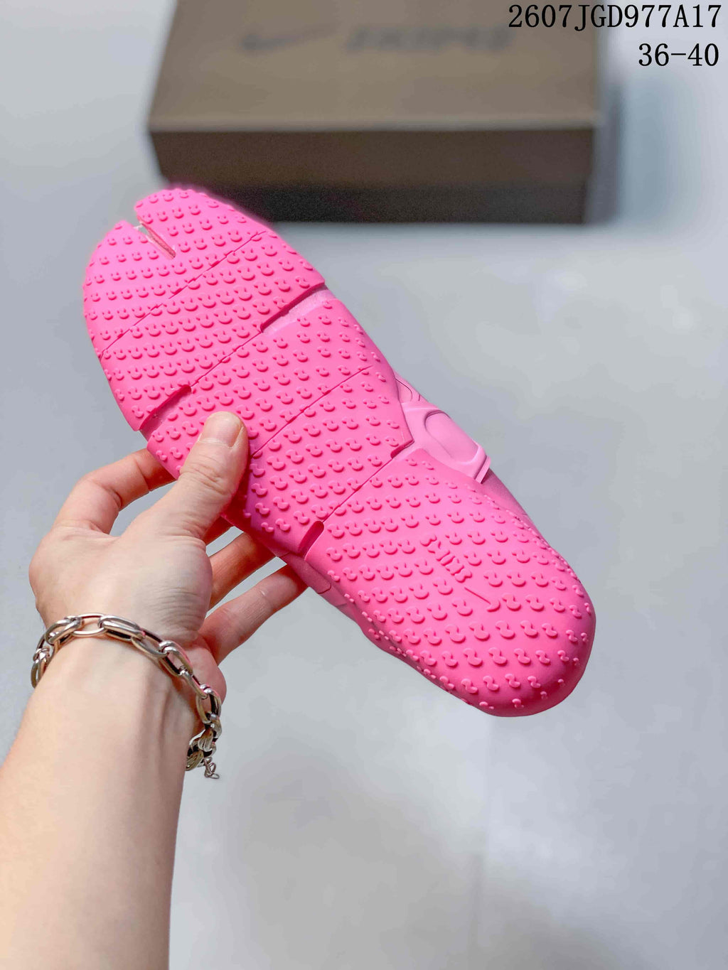Close view of the pink sneaker outsole showing raised textured traction details and segmented flex grooves.
