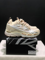Side view of cream OFF-WHITE Be Right Back sneakers with layered panels, arrow detailing, and chunky soles.