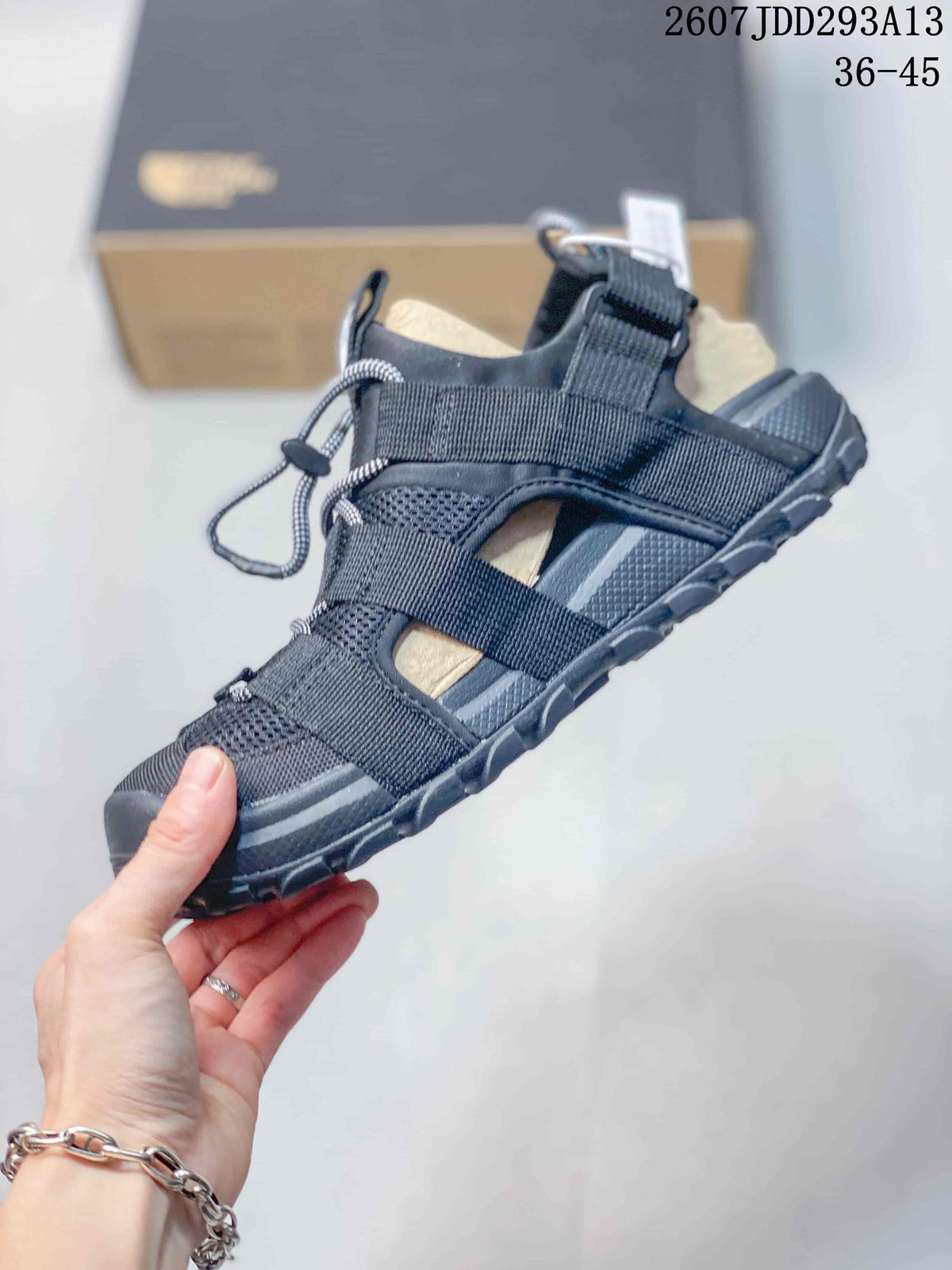 Side view of a black outdoor sandal showing the layered adjustable straps, mesh panels, and rugged sole.