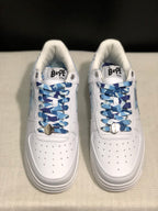 Front top view of the pair showing the perforated white toe panels and blue patterned laces with metal accessories.