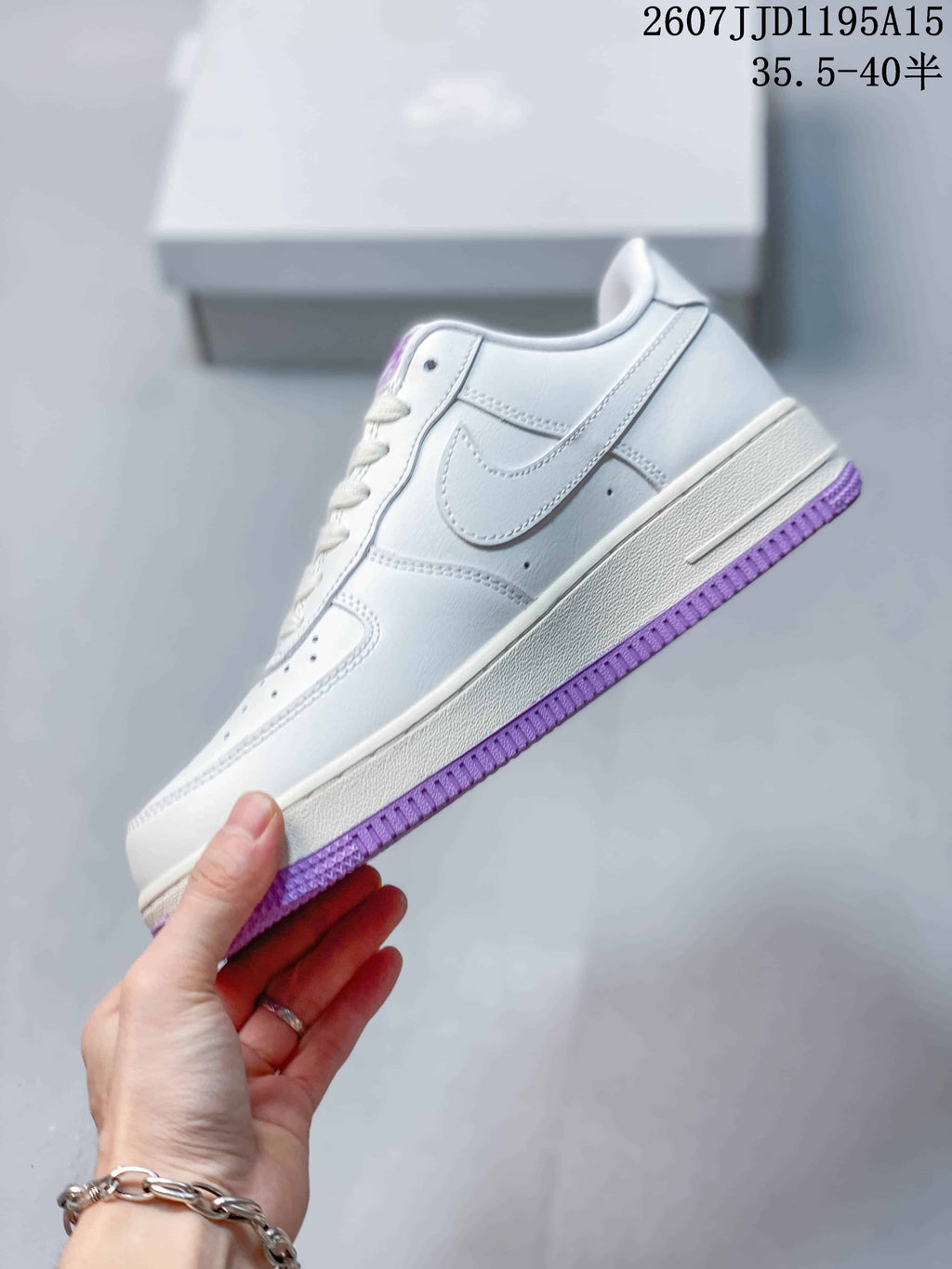 Side view of the white low-top sneaker with a white Swoosh and purple outsole edge.
