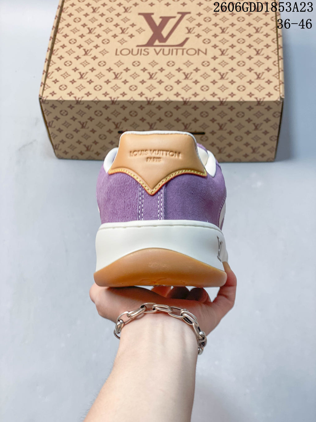 Rear view of the purple sneaker with a tan heel tab and contrasting sole.
