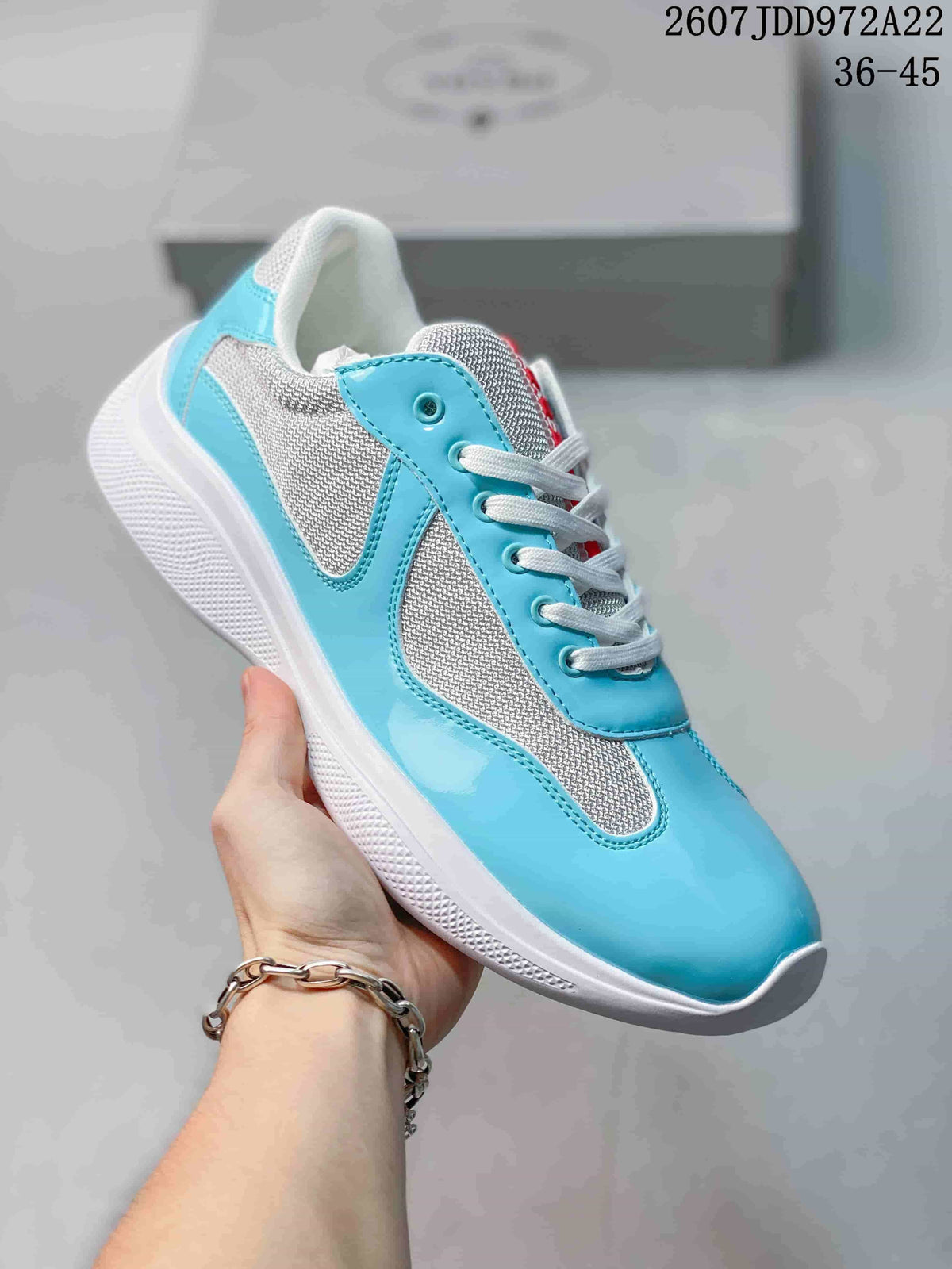Light blue and white Prada America's Cup low-top sneaker with white laces.