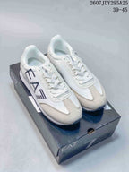 Pair of white and light beige EA7 Emporio Armani low-top sneakers displayed on a branded shoebox; style code 2607JDY295A25 and size range 39–45 are visible.