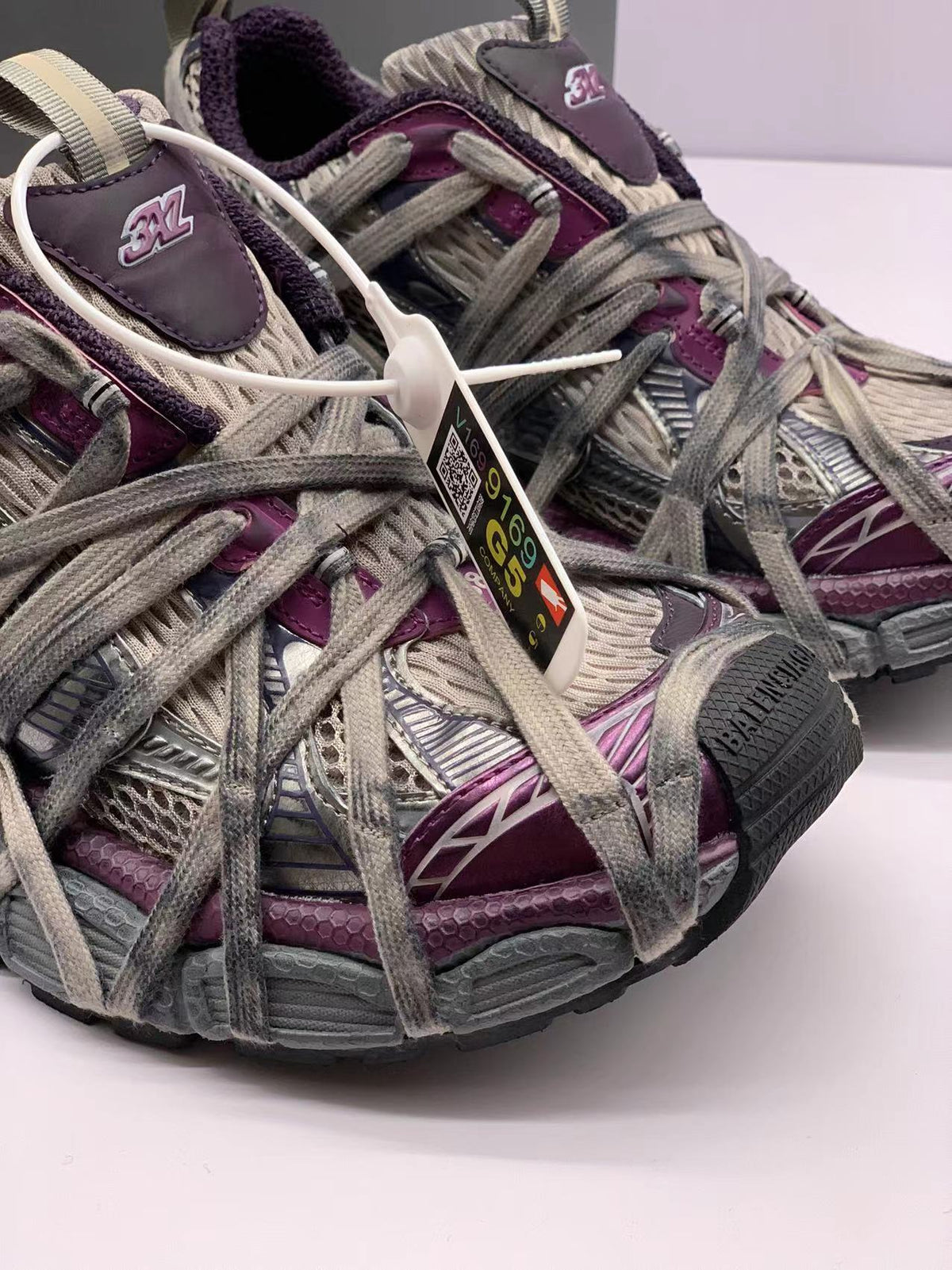 Close-up of the sneaker toe, layered upper, extended laces, and 3XL tongue branding.