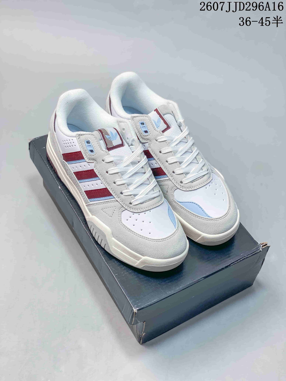 Pair of white adidas Originals Tekkira Cup sneakers with red and light blue accents displayed on a shoebox.