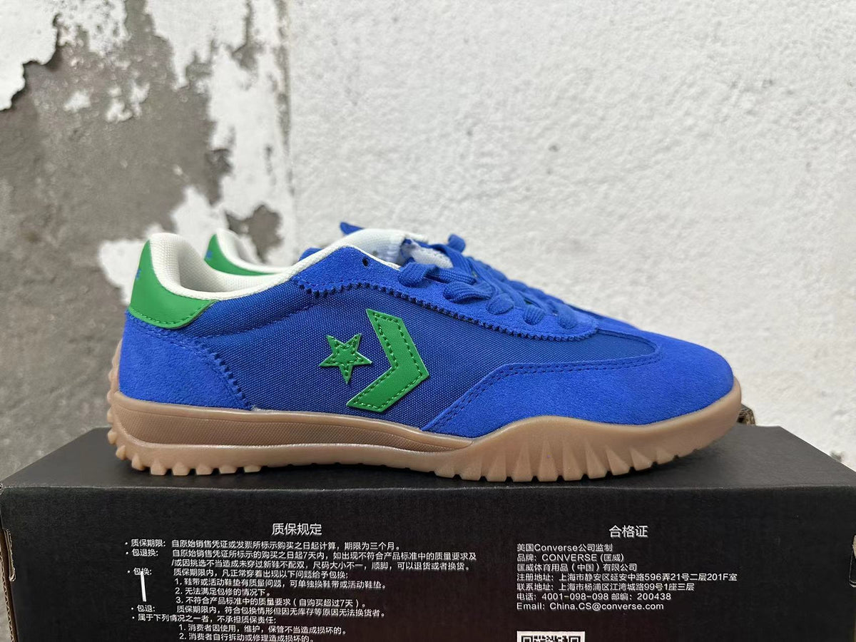 Side view of a blue Converse shoe with green star-and-chevron detailing and a gum-colored outsole