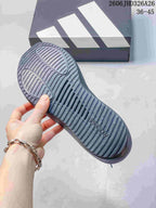 Close-up of the ridged outsole on a charcoal adidas running shoe