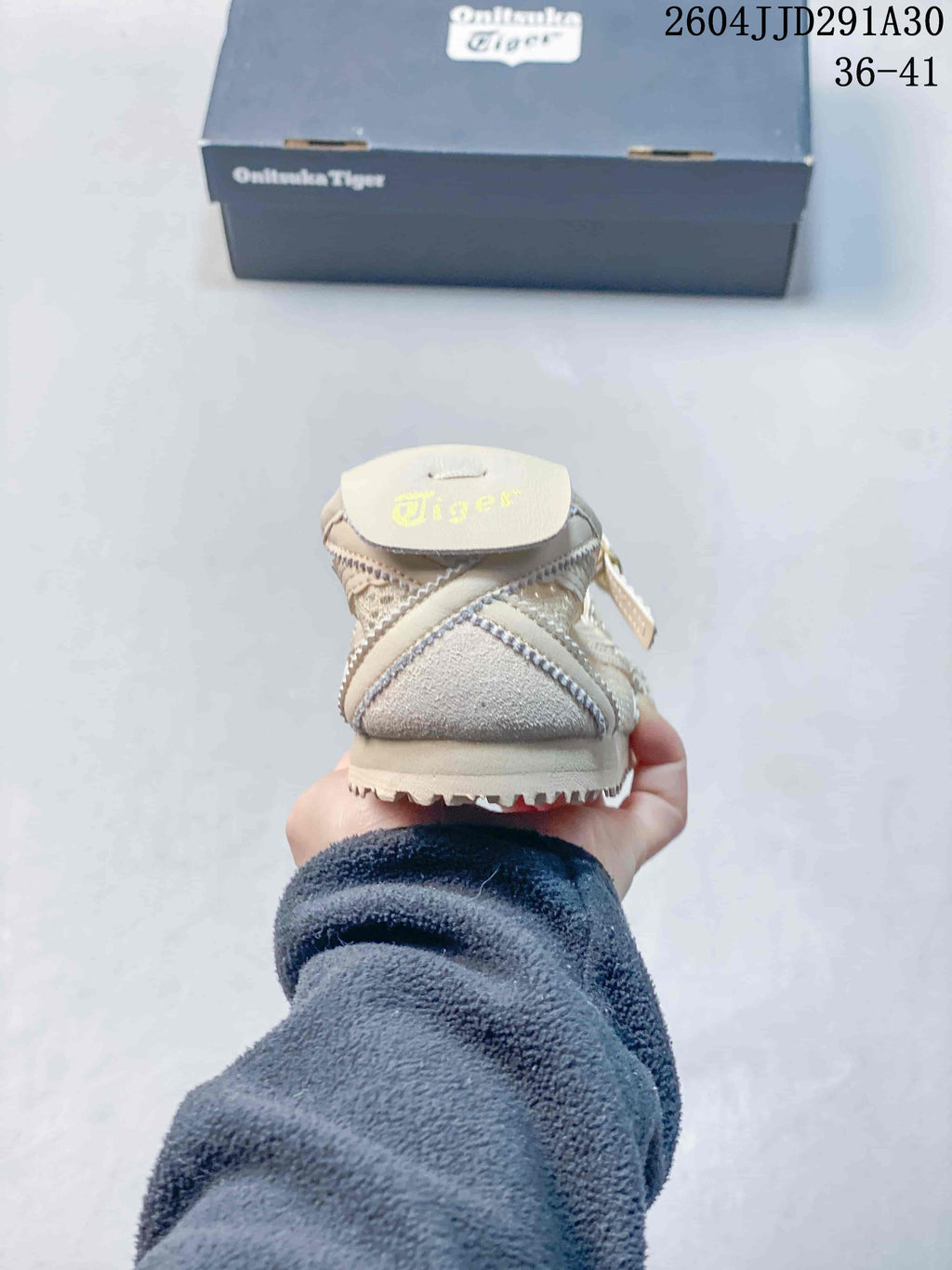 Rear view showing the padded heel and outsole edge of the cream sneaker.