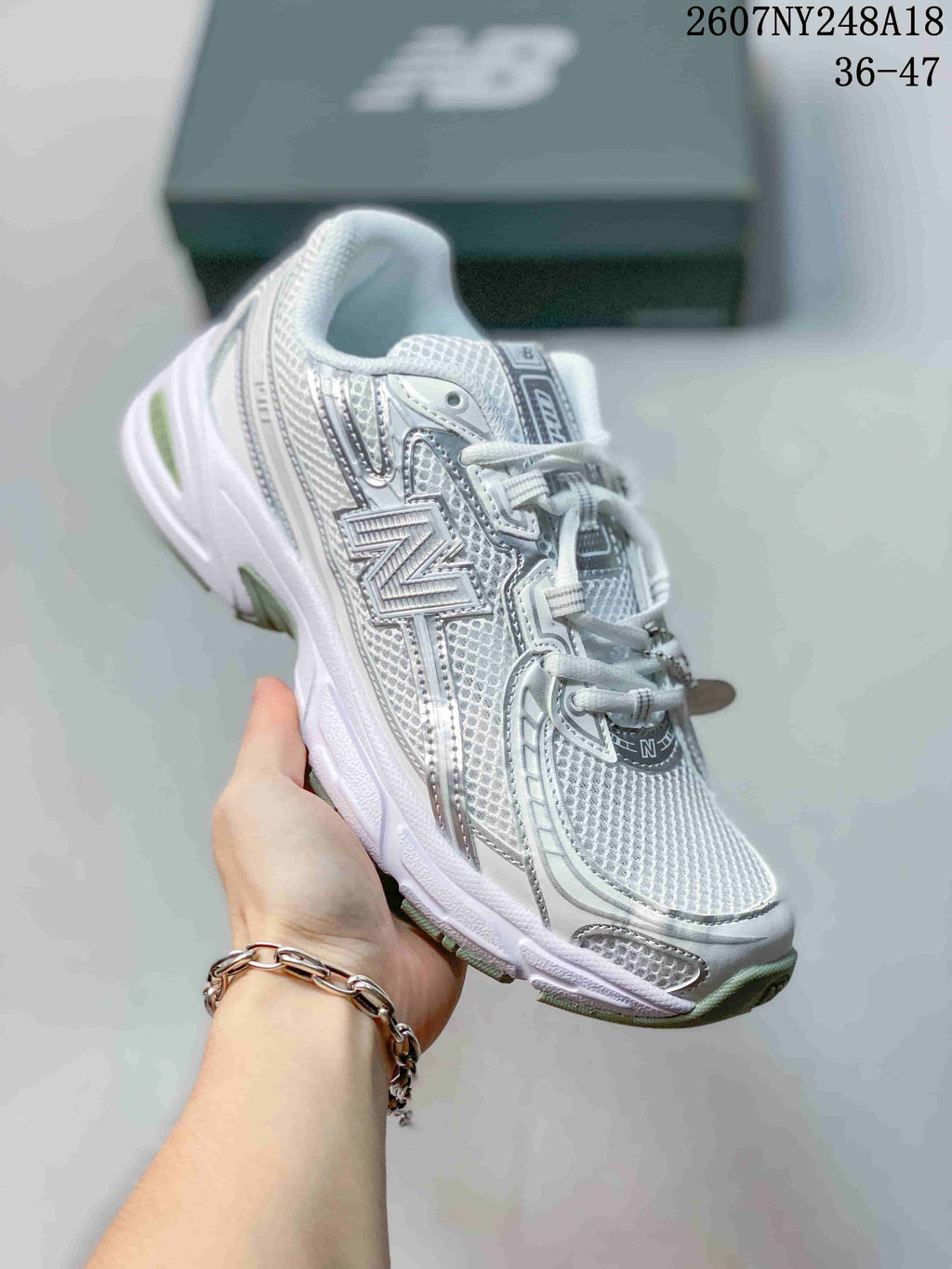 Side three-quarter view of the New Balance sneaker showing the large side logo, layered panels, and textured upper.