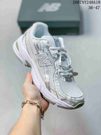Side three-quarter view of the New Balance sneaker showing the large side logo, layered panels, and textured upper.