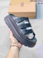 Close-up side view of a black UGG GoldenGlow slide sandal showing its thick textured outsole.
