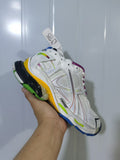 Angled close-up of a white Puma Runner Gradient sneaker showing multicolor overlays, mesh panels and a colorful outsole.