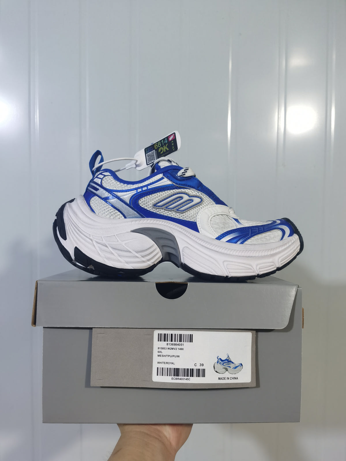 White and royal blue Skechers 1490 sneaker displayed on its box; the box label shows a sample size of C 39 and the color WHITE/ROYAL.
