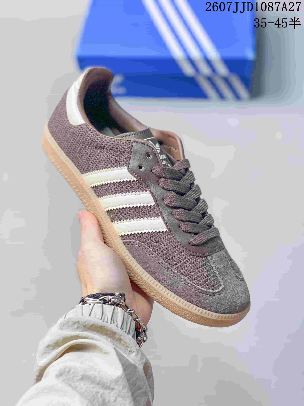 Angled side view showing the low-top silhouette, brown upper, white stripes, and gum-colored sole.