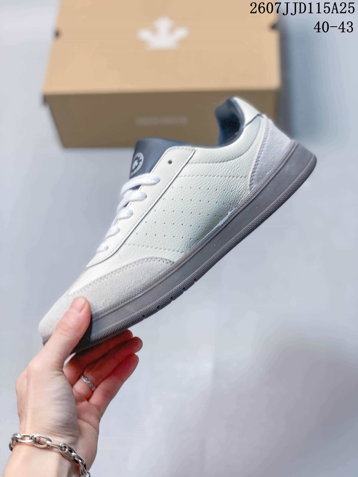 Side view of the white and navy low-top sneaker with layered panels and gray outsole