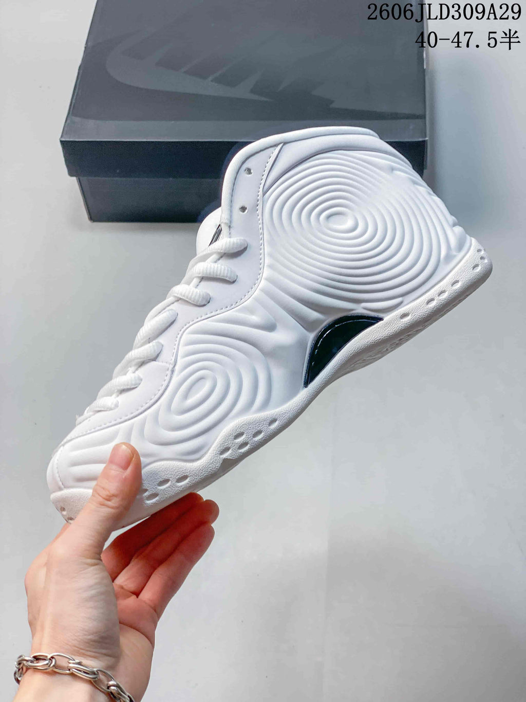 Side view of a white high-top sneaker showing its sculpted ripple-patterned upper.