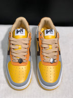 Front top view showing the yellow toe boxes, beige laces, tongue labels, and padded collars.