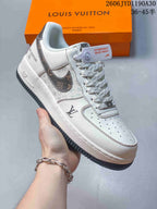 Cream low-top sneaker with dark patterned Swoosh and matching patterned laces.