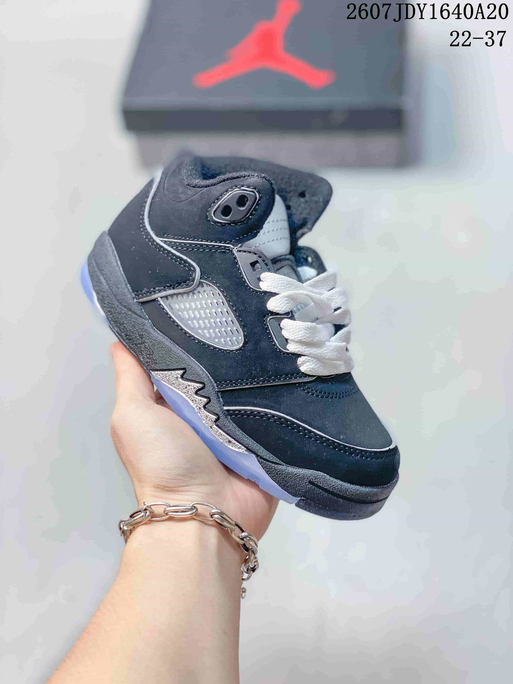 Dark navy and gray kids' mid-top sneaker with white laces and a translucent-looking outsole.