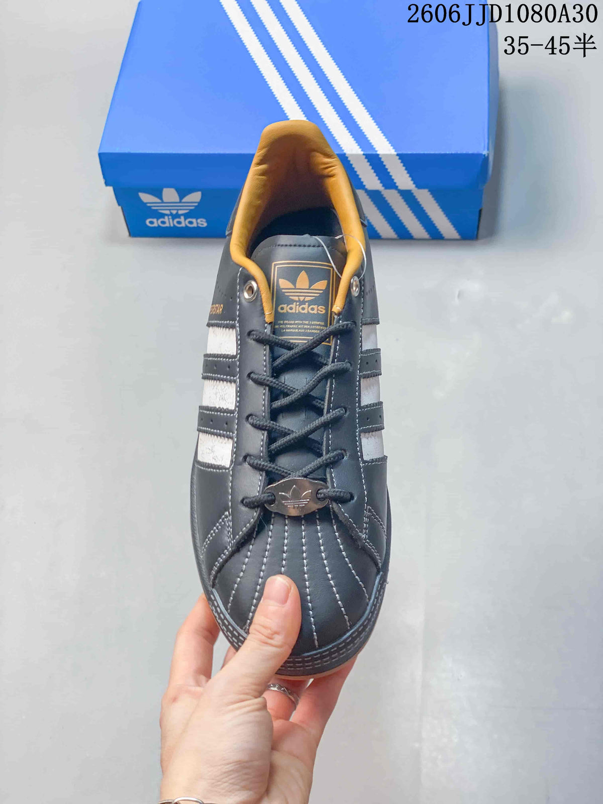 Top view of an adidas Superstar sneaker showing the shell toe, laces, and tan lining