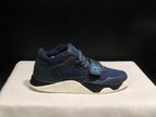 Single lateral view of the dark Jordan Jumpman Jack sneaker with navy panels, blue strap detail, and cream sole.