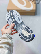 Underside view of the silver and blue sneaker showing the segmented black, gray, and white outsole pattern.