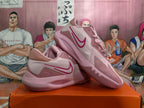 Pink Nike basketball shoes displayed together, showing side profile and patterned outsole.