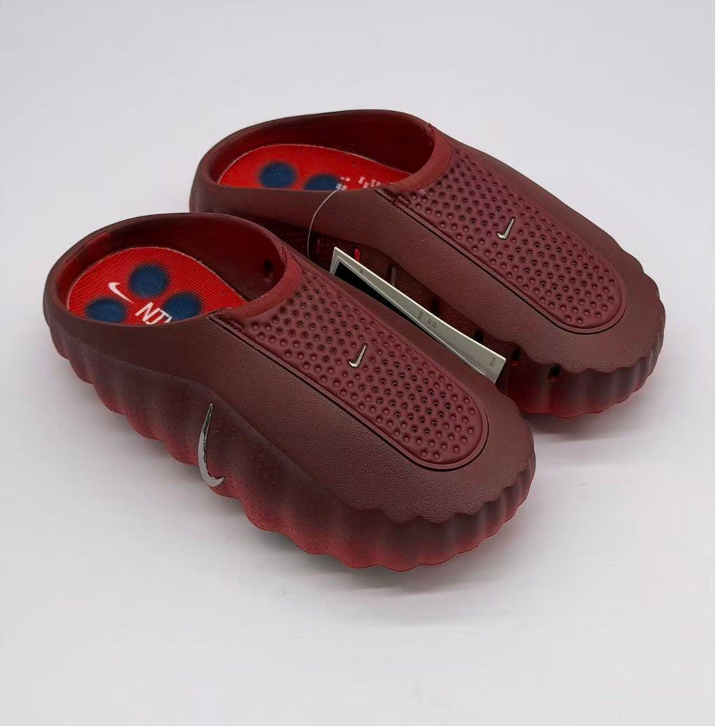 Pair of dark red slip-on sneakers showing the perforated panels, textured insoles, and side swoosh details.