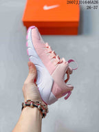 Side view of the pink and white training shoe showing the lace area, upper panels, heel pull tab, and white midsole section.