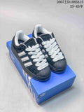 Black and white Adidas Superstar XLG sneakers displayed on a blue shoebox, showing the shell toes, white laces, and raised sole.