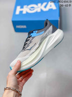 Side profile showing the light gray mesh upper, black and blue overlays, sculpted white sole, and blue outsole edge.