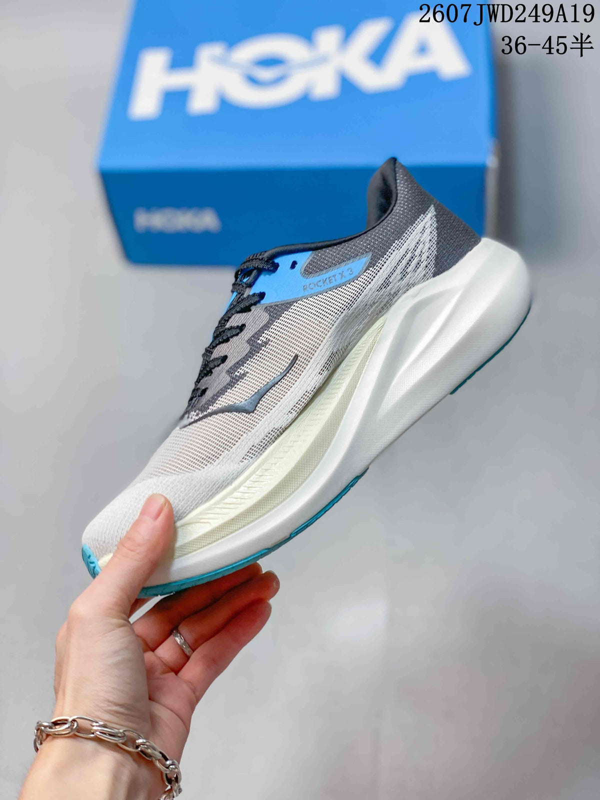 Side profile showing the light gray mesh upper, black and blue overlays, sculpted white sole, and blue outsole edge.