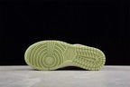 Bottom view showing the light green outsole with circular forefoot and grid-pattern traction.